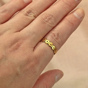 Golden daisy flower pattern stainless steel ring for women shown on a hand