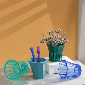 Detail of colorful faceted resin molds for making DIY vases and striped desktop organizers