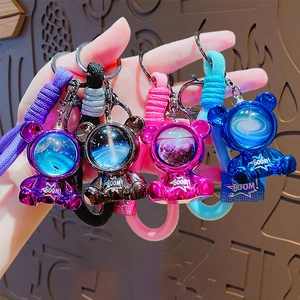 Astronaut space bear keychains in purple, black, pink, and blue with braided straps