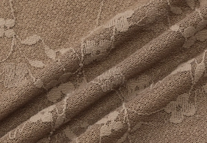 Détail du tissu en dentelle marron avec texture de maille florale et drapé délicat