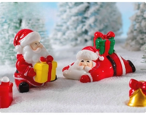 Miniature Christmas Santa Claus resin figurines in a snowy winter landscape display