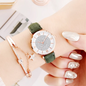 Detail van roségouden horloge met strass-wijzerplaat, groene band en sterrenarmband