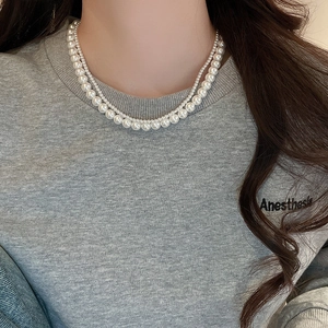 Close-up of elegant double-layered pearl necklace worn on a neck for chic styling