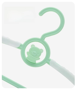Detail of cartoon bear embossing and non-slip white pads on a green children hanger