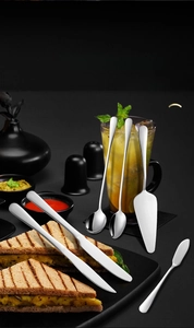 Detailed view of polished stainless steel steak knives and long handled ice spoons