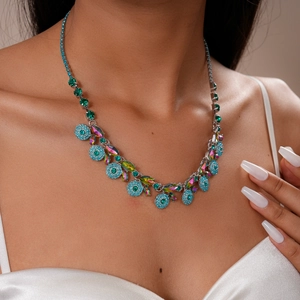 Detailed close-up of Bohemian rhinestone floral necklace with blue crystals on model