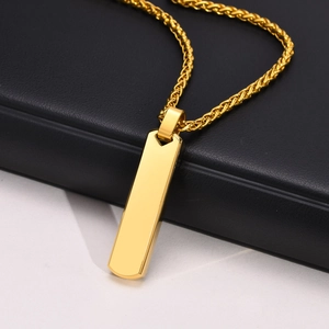 Close-up of golden rectangular bar pendant necklace on black leather and white surface