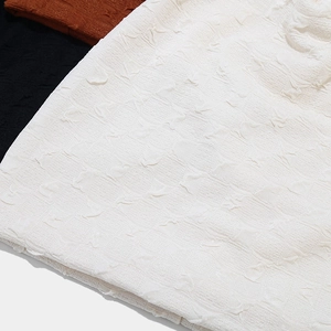Macro detail of 3D jacquard knit texture on casual beanies in white, black and brown