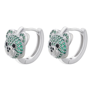 Macro shot of silver teddy bear earrings inlaid with sparkling green cubic zirconia