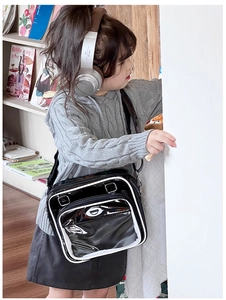 Détail d'un enfant portant un sac ita en cuir verni noir avec fenêtre transparente