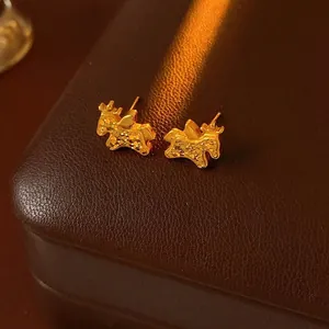 Elegant gold plated elk stud earrings with a shimmering texture on a brown leather box