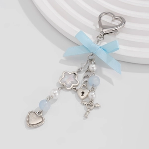Sweet heart bow ribbon keychain with blue beads and silver metal pendants on display