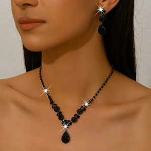 Elegant jewelry set with black rhinestones featuring necklace and earrings on a model