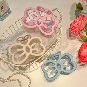 Elegant large matte bow hair claws in pink, beige, and blue for women's hair styling