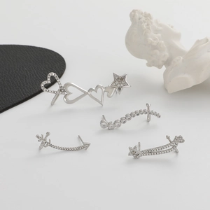 Macro shot of silver zircon ear cuff set with heart and star patterns on black leather