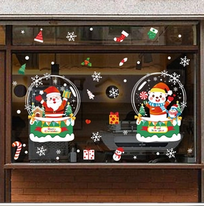 Detail of Christmas window decals featuring Santa Claus, penguins and snowflakes on a glass pane