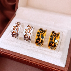 Detail of vintage leopard print C-shape hoop earrings with silver and gold metal finish