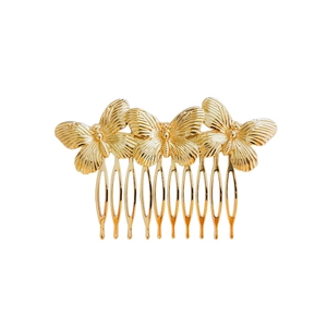 Detailed close-up of three golden butterflies on a minimalist vintage metal hair comb