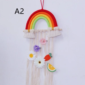 Detail of bohemian woven rainbow wall hanging with decorative macrame tassels and clips