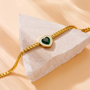Parure coeur doré avec pierre vert émeraude et zircons sur support en pierre brute