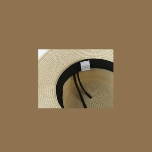Detail of 100% paper straw hat interior with adjustable strap and quality label
