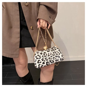 Detail view of leopard print crossbody bag with gold chain strap and pearl buckle accent