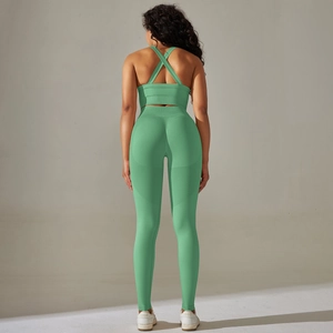 Detail of cross-back mint green sports bra and high waist yoga leggings on model