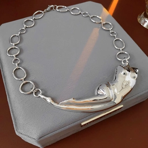 Vue détaillée de ce collier en métal froissé avec pendentif de silhouette féminine