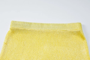Macro view of bright yellow fine knit fabric texture and high-quality waist seam detail