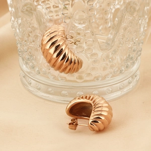 French vintage 18K rose gold plated ribbed croissant stud earrings on beige background