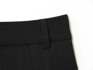Detailed macro view of black twill fabric texture and waistband stitching on trousers
