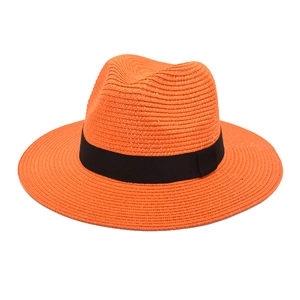 Close-up of bright orange straw Panama hat featuring a contrasting black ribbon band