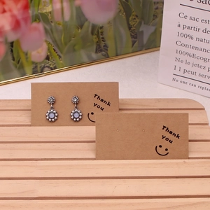 Detail of vintage silver flower earrings with pearls on Kraft thank you card