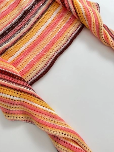 Detail eines bunten gestreiften Strickoberteils mit Pailletten und Lochmuster