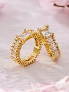 Macro view of gold plated emerald cut zircon ring set with pave small baguette stones