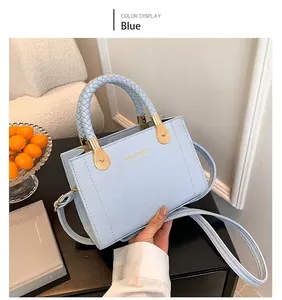 Détail du sac à main bleu clair à carreaux avec poignée tressée et boucle dorée