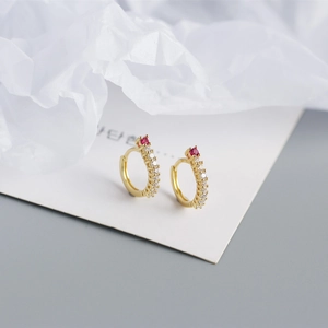 Detail view of gold S925 sterling silver hoop earrings with red gem and white zircon row
