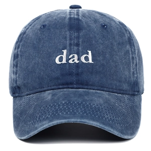 Close-up of white dad embroidery on washed navy blue cotton denim baseball cap