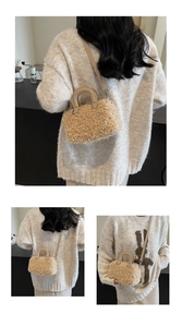 Detail of plush beige boston bag featuring leather handles and detachable shoulder strap