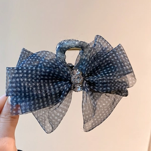 Detail of navy blue mesh hair claw with white polka dots and sparkling rhinestones