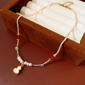 Macro detail of calabash pendant necklace with freshwater pearls and red crystal beads