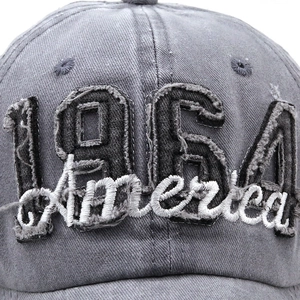 Close-up of 1964 patch and white 3D America embroidery on gray washed denim baseball cap