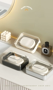 Three multi-color double-layer soap dishes with clear lids on a bathroom vanity