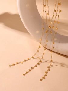 Detail of 18K gold-plated Y-necklace featuring circular disc charms on thin chains