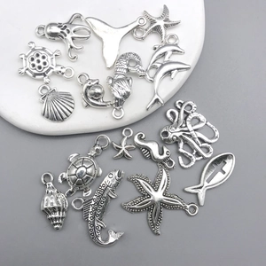 Detalle de dijes marinos en plata antigua con tortugas y caballitos para joyería artesanal