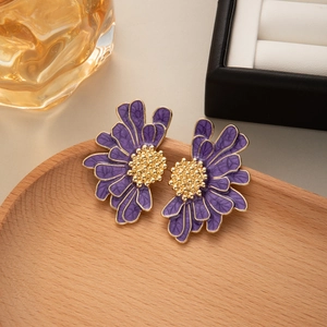 Macro detail of French vintage daisy earrings with purple petals and golden center accents