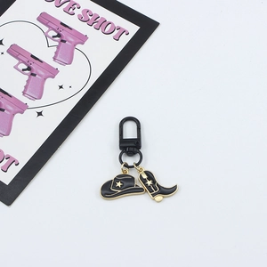Detail of Western cowboy keychain with black hat and boot charms on Love Shot card