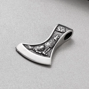 Vue macro détaillée du pendentif hache viking en acier avec relief de loup et symbole Valknut