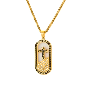 Macro detail of 18K gold plated cross pendant with rhinestones and Greek key border
