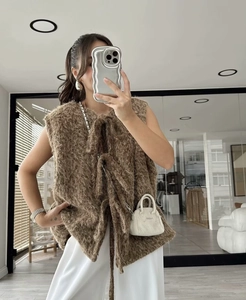 Close-up of brown fuzzy mohair vest with tie-front detail on model for cozy look